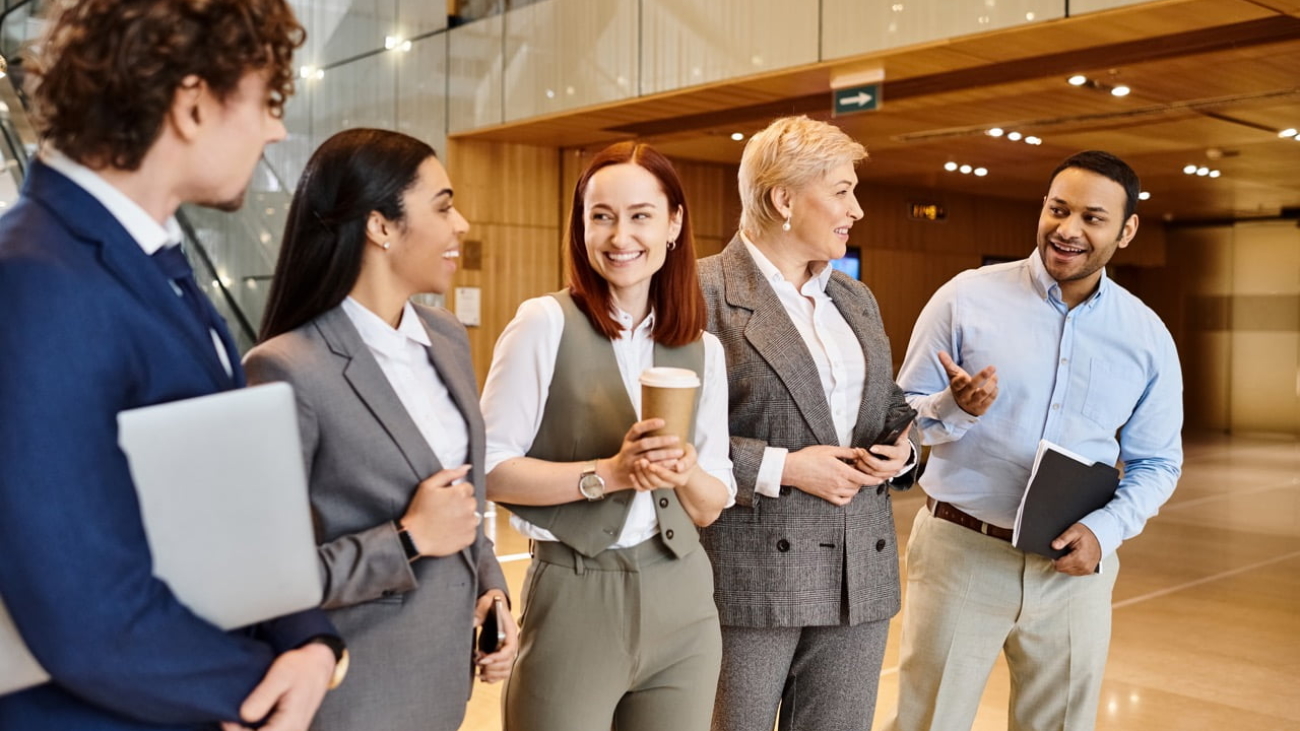 Multicultural business professionals gather in a lobby for a meeting.